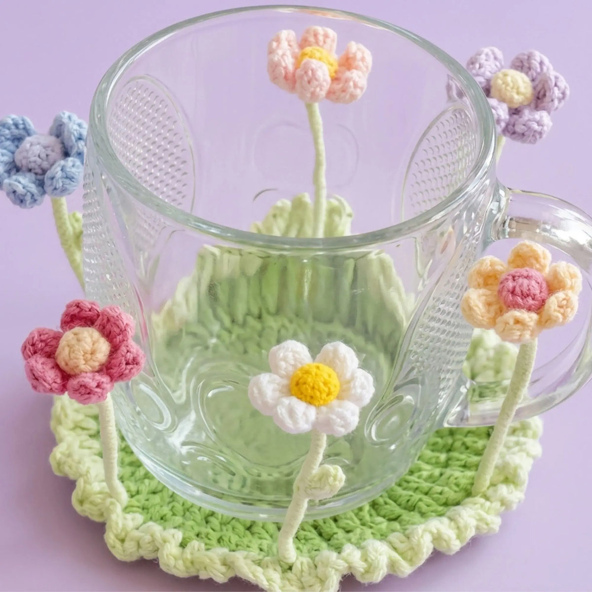Pastel flower crochet coaster under a clear glass mug