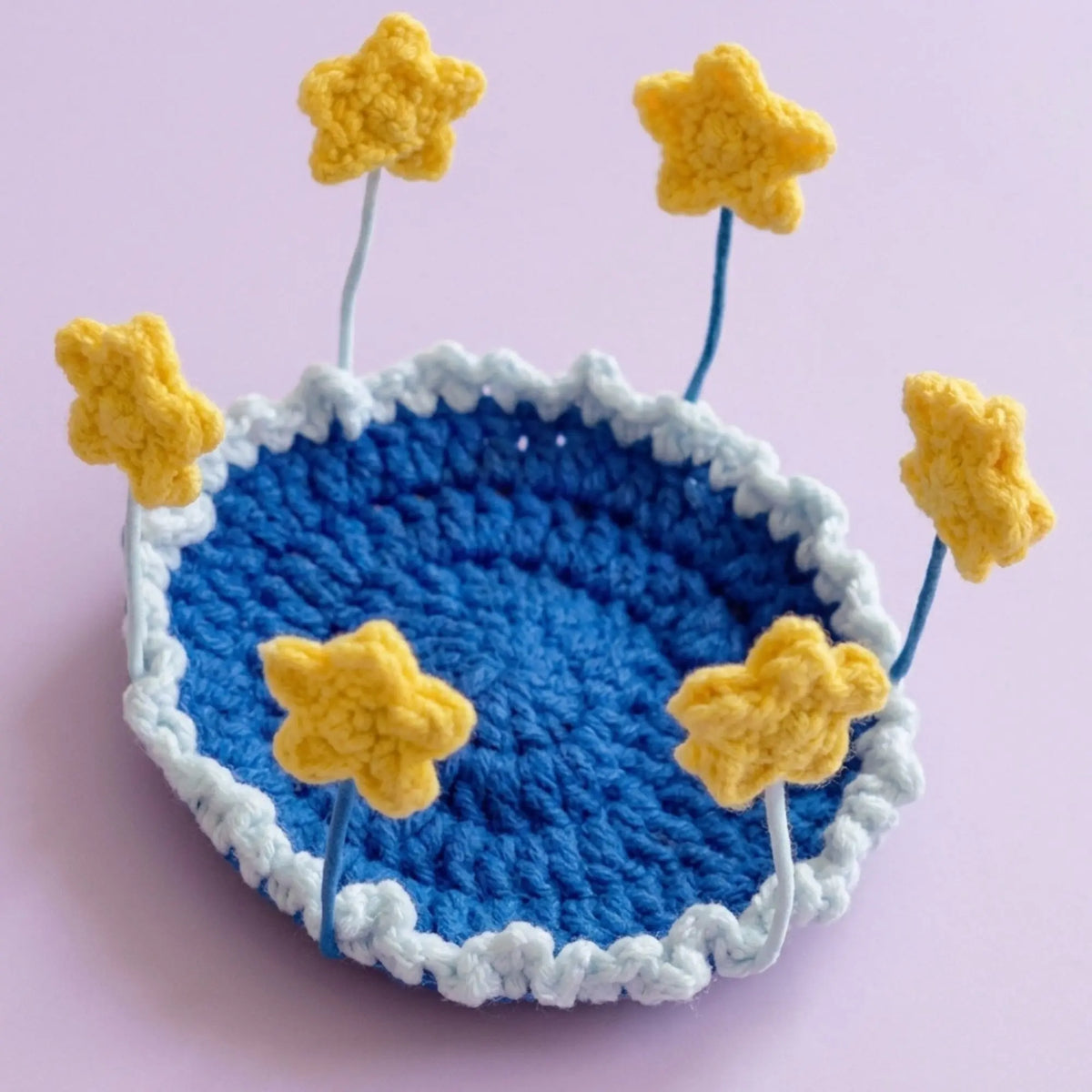 Yellow star pop-up crochet coaster on a blue base