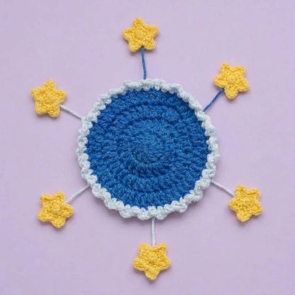 Flat blue crochet coaster with yellow stars on spread-out stems