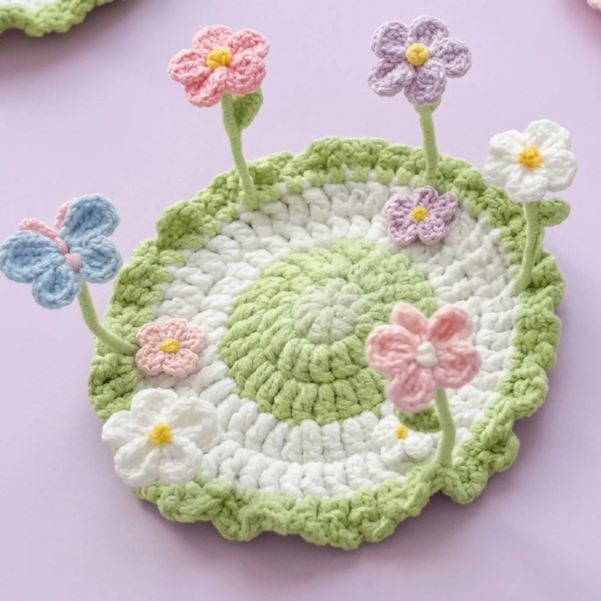 Crochet pop-up garden coaster with pink, purple and blue flowers on wire stems