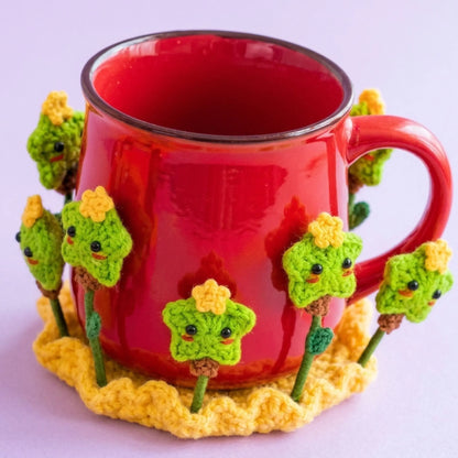 Red mug on a crochet coaster with green and yellow star flowers