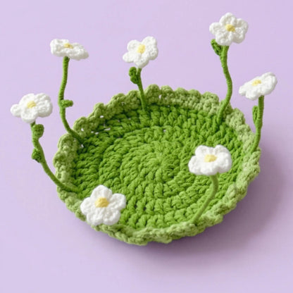 White daisy pop-up crochet coaster on a green base