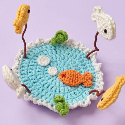 Goldfish pond crochet coaster with fish and lily pads on wire stems