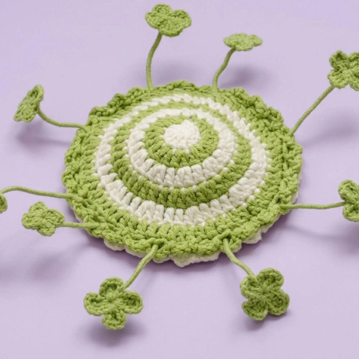 Lucky clover crochet coaster with green stripes and four-leaf clovers