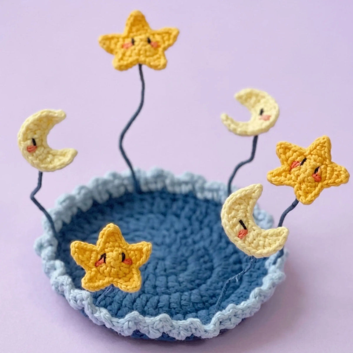 Moon and stars crochet coaster on a navy blue base