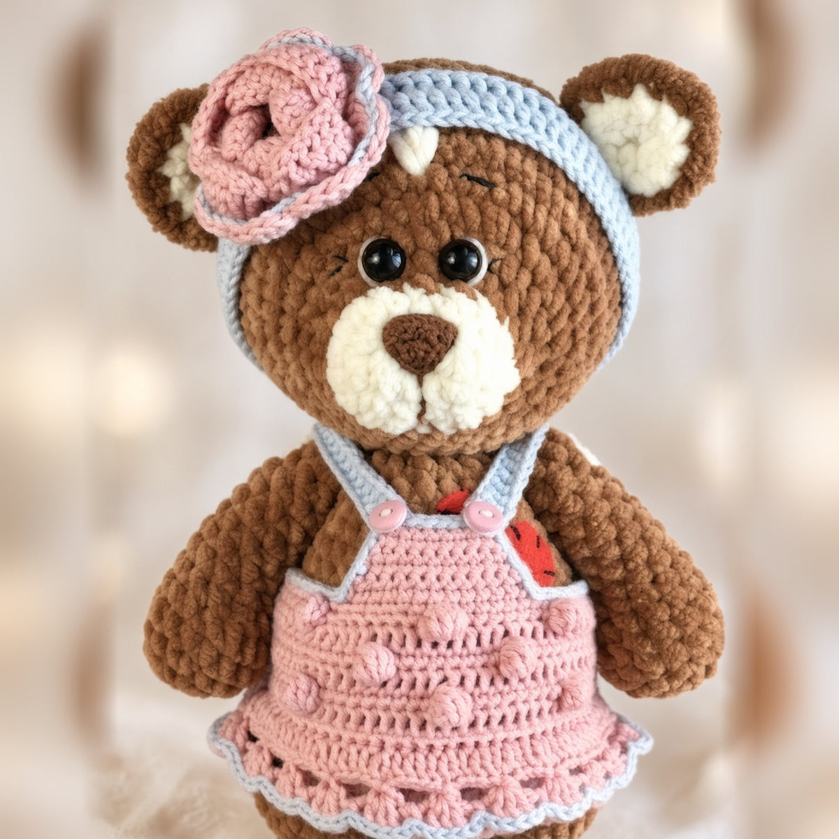 Brownie plush bear in a pink crochet overall dress with a rose headband