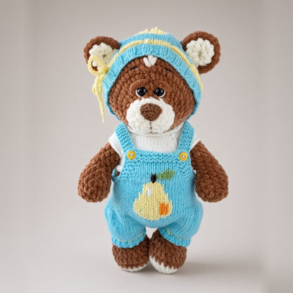 Brownie plush bear in a knitted blue T-shirt, overalls and hat with a pear motif