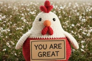 Cute crochet chicken amigurumi holding a sign that says "You Are Great" – handmade gift idea by MrsCrochetWorld